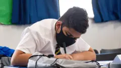تلميذ يرتدي قناعا أثناء الدرس في ليسترشاير