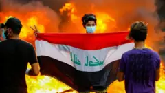 متظاهر يحمل العلم العراقي في بغداد