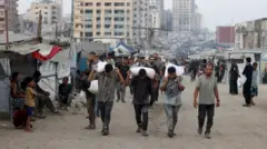 Homens carregando vários sacos nas costas