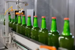 Garrafas de cerveja verdes em linha de produção