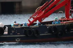 Passageiros do navio de cruzeiro MV Hondius, afetados por um surto de hantavírus, são transferidos de barco para o porto após desembarcarem em Tenerife