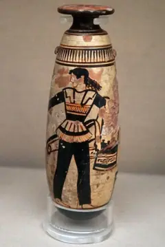 Vaso com cores dourada e preta, com o desenho de uma mulher com calças pretas