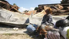 Una mujer sentada cerca de los restos de un banco destruido en Palma, provincia de Cabo Delgado, Mozambique, el 30 de septiembre de 2022.
