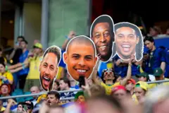 Torcedor do Brasil segura fotos imensas dos rostos de Neymar, Ronaldo, Pelé e Ronaldinho Gaúcho