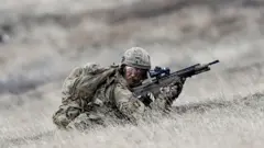 Британский военнослужащий в полевой экипировке на учениях