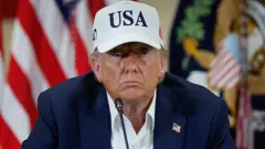 Donald Trump con una gorra que dice USA