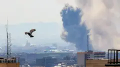 Uma coluna de fumaça se eleva sobre Teerã após um ataque com mísseis à cidade no início de abril de 2026. Um pombo é visto subindo ao céu após a perturbação.