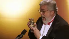 مؤسس جائزة "التوتة الذهبية" لأسوأ الأفلام، يحمل الجائزة التي تبلغ قيمتها 5 دولارات