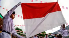Sejumlah anggota paskibra mengibarkan bendera Merah Putih saat mengikuti upacara di SD Negeri 1 Kota Ternate Maluku Utara, Sabtu (17/8/2024). 