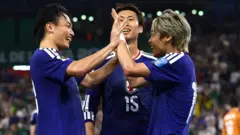 青色ユニホームを着た3選手が笑顔で集まっている。伊藤と上田は両手を合わせている
