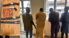 Awọn afurasi merin tiu ọlọpaa mu duro, oniruuru ibọn ati ọta ibọn wa lori tabili