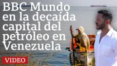 Norberto Paredes, de BBC Mundo, en primer plano con una camisa blanca y con el lago de Maracaibo y un pescador sentado en una barca de fondo.