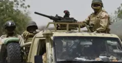 Military personnel wey dey inside armoured vehicle fully armed