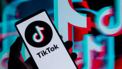 Mão segurando celular com TikTok instalado