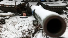 Soldado ucraniano abaixado perto de canhão na neve