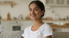 සුදු පැහැති ටී ෂර්ට් එකක් ඇඳ, සිනහ වෙමින් කැමරාව දෙස බලා සිටින සිටින කාන්තාවක්. ඇගේ උඩු කය පමණක් දර්ශනය වෙයි. 