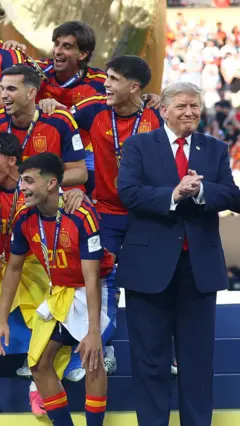 Трамп задержался на сцене с чемпионами-футболистами.