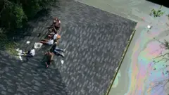 Un grupo de sobrevivientes de Katrina en el techo de una casa