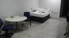 Vista do quarto-sala. As setas mostram a campainha de pânico/emergência e a barra de apoio à beira leito