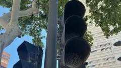 Semáforos em um poste em uma cidade na Espanha está escura, sem eletricidade