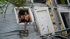 Un hombre en una ventana de una casa destrozada tras los sismos del miércoles 24 de junio en Venezuela
