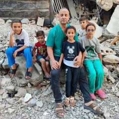 Alathamna y sus niños sentados entre ruinas