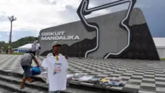 Seorang pria menjual kaos suvenir jelang balapan MotoGP Grand Prix Indonesia di Sirkuit Internasional Mandalika di Kuta Mandalika di Lombok Tengah pada 18 Maret 2022.
