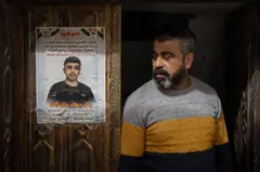 El padre de Jad Jadallah está de pie junto a un cartel conmemorativo por la muerte de su hijo de 14 años.