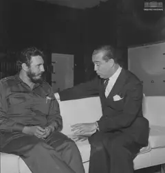 Fidel Castro e Kubitschek sentados em um sofá branco em uma foto em preto e branco.