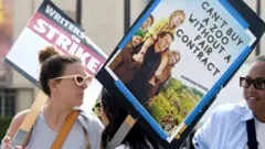 أشخاص يمسكون لافتات