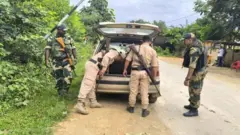 मणिपुर में गाडियों की तलाशी लेते सुरक्षाकर्मी