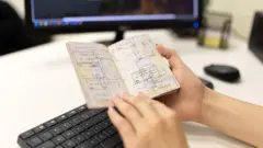 Žena drži otvoreni pasoš na čijim stranicama su različiti pečati