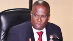 Minisita tẹlẹ, Timipre Sylva, wọ asọ kootu alawọ aro, o wọ shaati funfun to si de tai alawọ waini, ẹrọ gbohungbohun ka wa niwaju rẹ, o na ọwọ bii ẹni to n sọrọ.