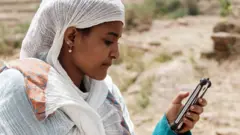 በትግራይ ክልል ሞባይል ስልክ እየጠቀመች ያለች ሴት