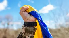 Чоловіча рука стискає прапор України