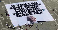 Manifestantes em Veneza com cartaz com a foto de Jeff Bezos e os dizeres "Se você consegue alugar Veneza para seu casamento, pode pagar mais impostos"