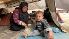 Raia wa Palestina 9 kati ya 10 wanaishi kwa mahema,ikiwemo Salwa Abu Nimwer[kushoto] akiwa na mtoto wake,wakiishi katika hali duni