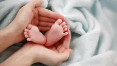 Umugore ufashe uturenge tw'uruhinja