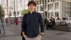 Andrés Azpurúa mengenakan kemeja lengan panjang gelap, difoto di sebuah jalan di Madrid. Ia menatap langsung ke kamera dengan ekspresi serius dan kedua tangan di dalam saku.