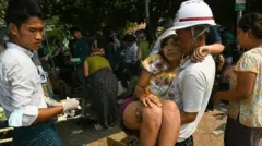 Una mujer es ayudada por los servicios de rescate de Myanmar.