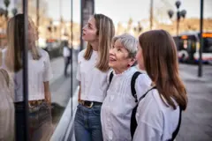 Bir mağazanın camına bakan iki genç, bir yaşlı kadın