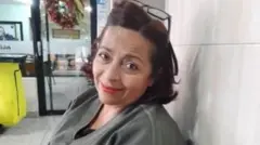 Orozco está olhando para frente. Ela está com os óculos de grau descansando na cabeça.