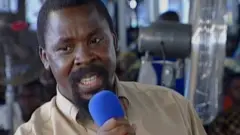 TB Joshua bin hold one blue microphone
