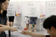제9회 전국동시지방선거 및 국회의원 재·보궐선거일인 3일 부산 부산진구청에 마련된 부암제1동제4투표소에서 아이들이 엄마가 투표하는 모습을 지켜보고 있다