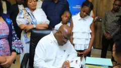 Perezida Tshisekedi arimo gusinya ku nyandiko ubwo yatangaga kandidatire mu kanama k'igihugu k'amatora, ku wa gatandatu, ku itariki ya 7 Ukwakira (10) mu 2023