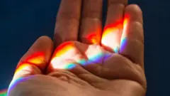 Рука зі світлом від веселки