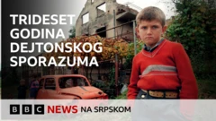 Dečak ispred razrušene kuće