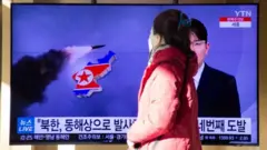 A woman watchs the news at a station in Seoul, South Korea, 17 January 2022.