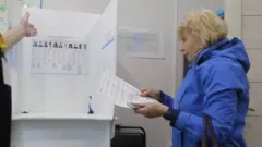 A woman prepares to cast her bulletin during an early voting in Moscow, Russia. Photo: 11 September 2020