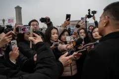 很多人拿著手機個話筒對準一個男性